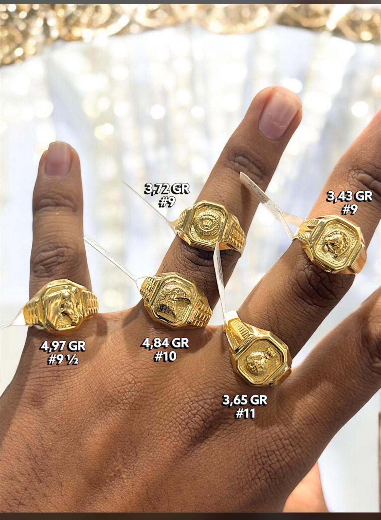 Mano real en el local luciendo anillos de sello de oro con sus etiquetas de gramos